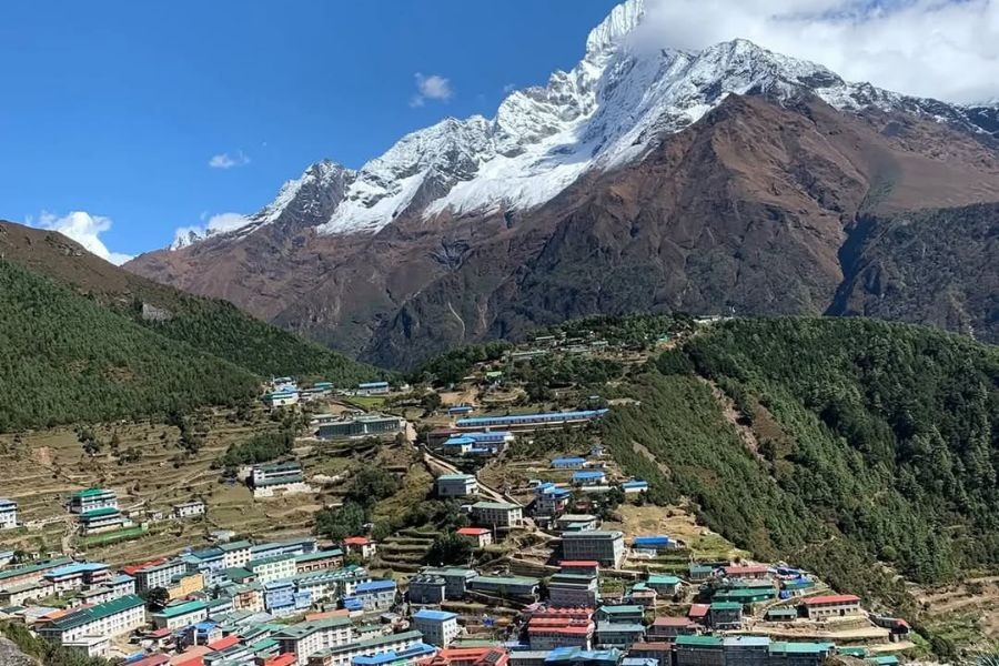 Namche Bazaar village with colorful buildings and snow-capped Himalayan peaks